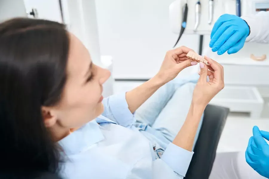 Paciente revisando su prótesis dental removible con la dentista