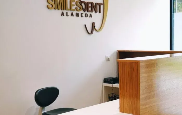Recepción de la clínica SmilesDent Alameda con el logo dorado