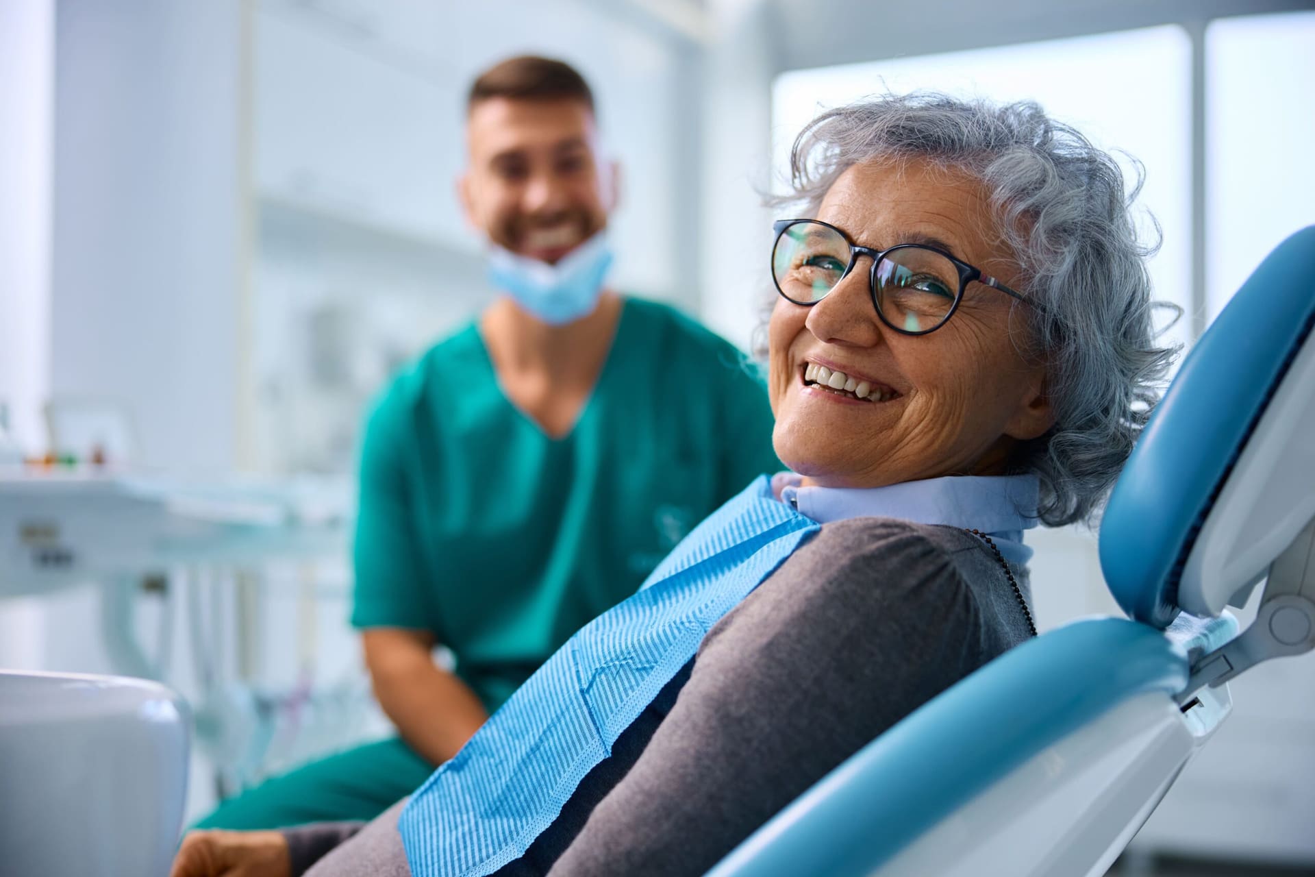 Paciente sonriente con su dentista tras un tratamiento de implantes dentales en Madrid