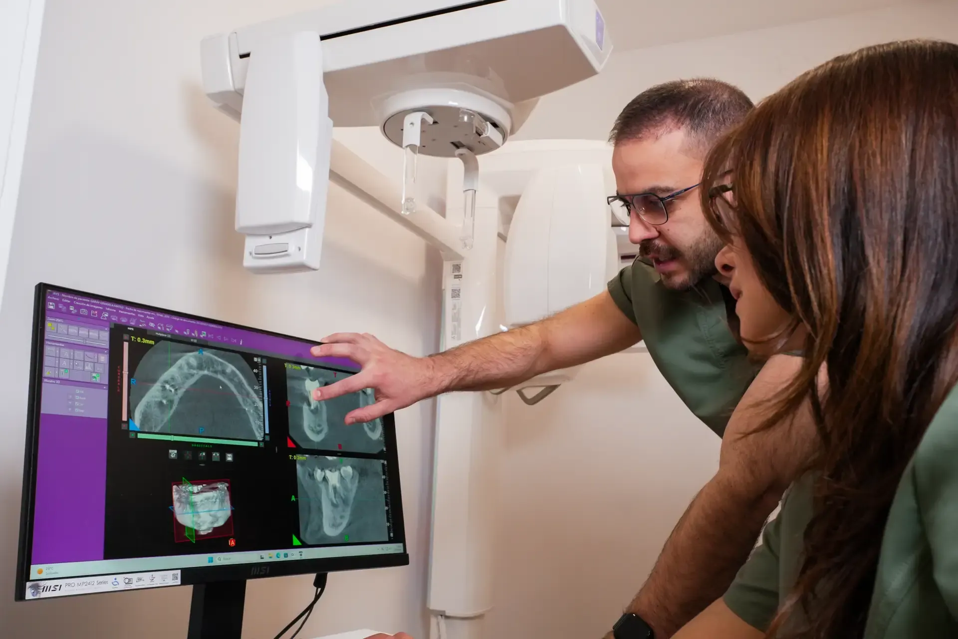 Dentistas revisando un escáner 3D (CBCT) en la pantalla de la clínica