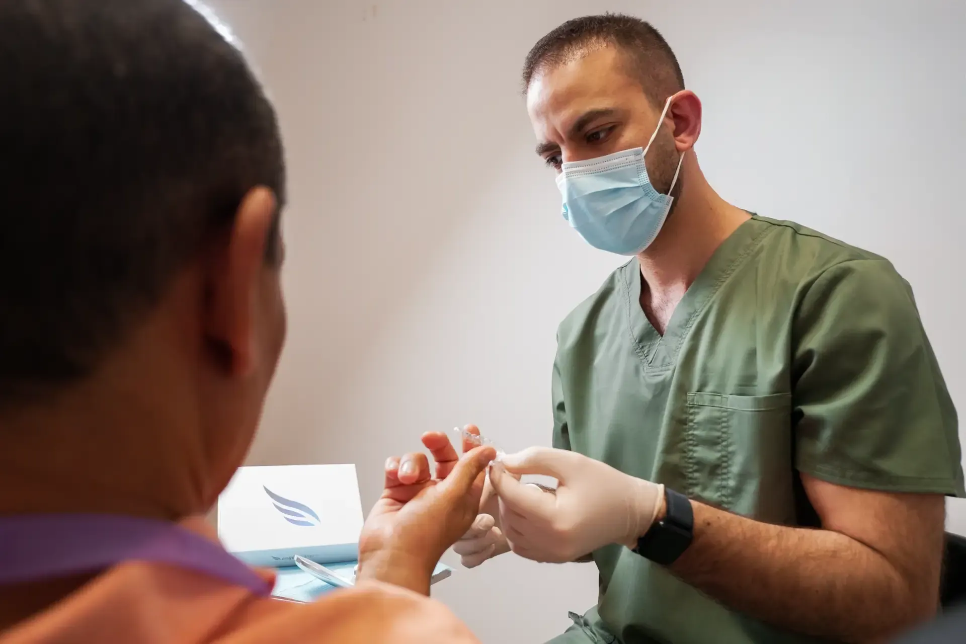Dentista revisando un alineador con un paciente en el gabinete